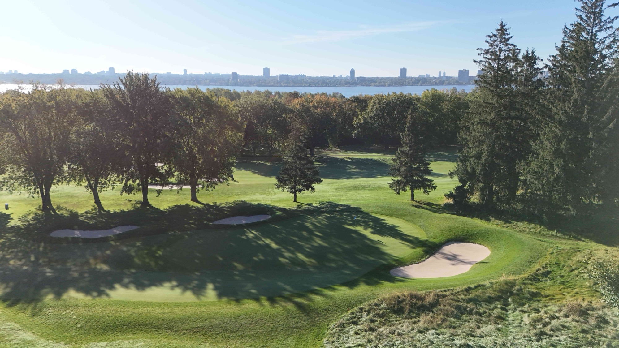 The sixth fairway from the air, curving through hardwoods