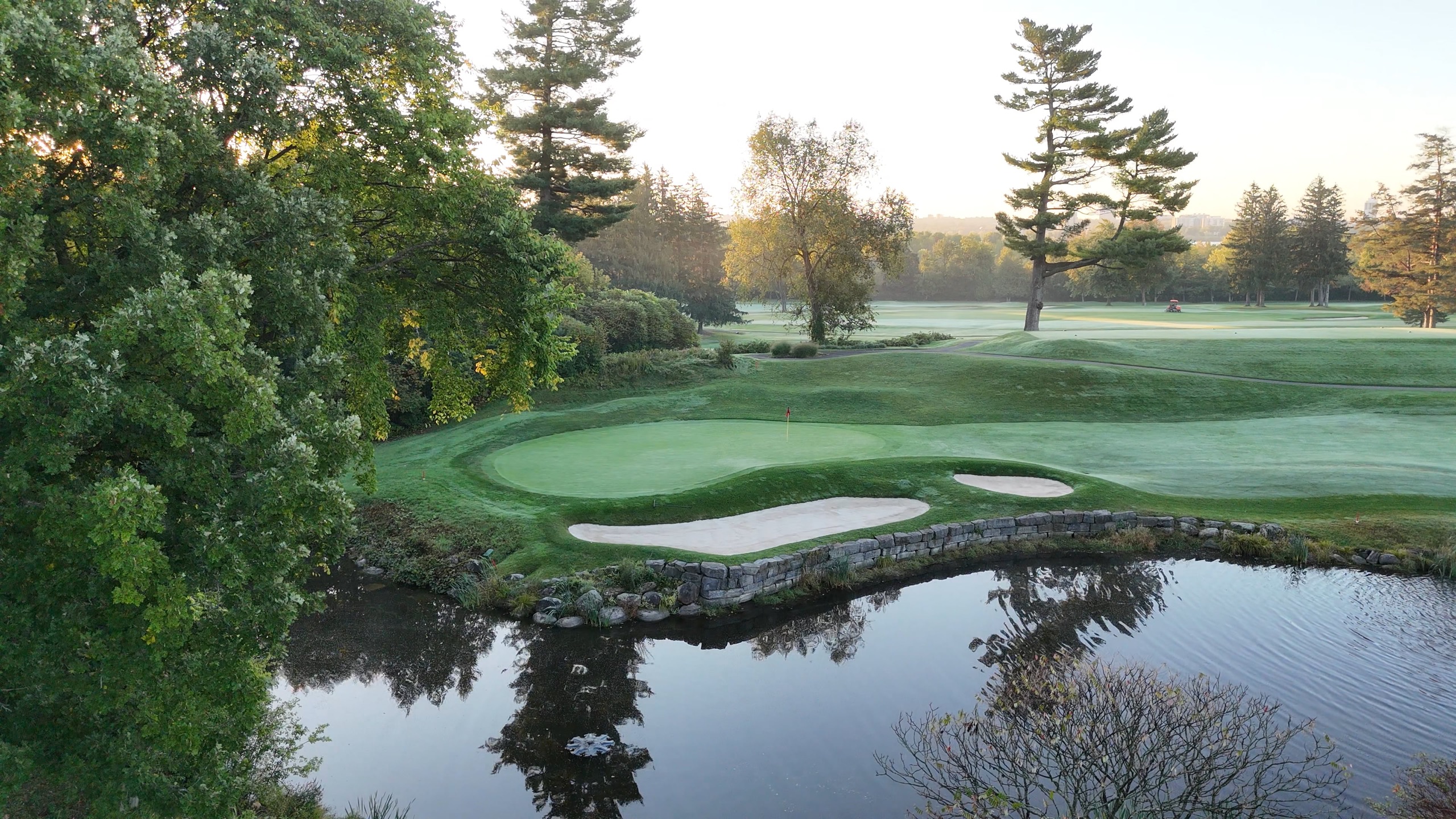 A Rivermead green at dawn, dew still on the grass, bunkers catching the first light